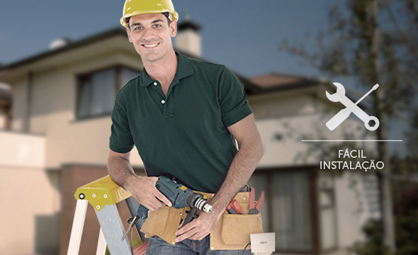 Mão de um instalador fixando a sirene na parede