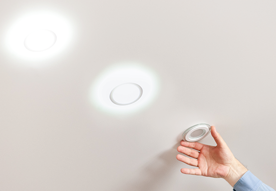 Lâmpada spot sendo instalada em um soquete GU10 no teto.