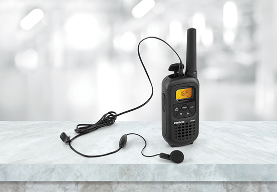 Pessoa utilizando o r&aacute;dio comunicador com um fone de ouvido